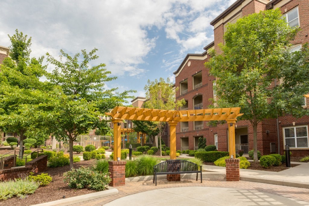 our apartments offer a courtyard with benches and a pergola