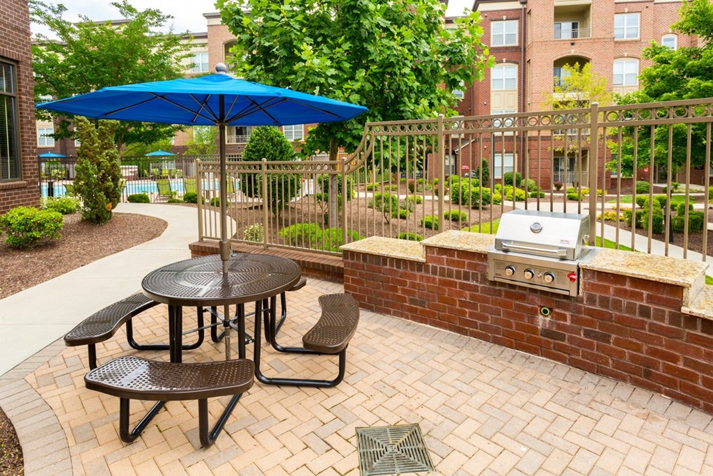 our patio has a grill and table with umbrellas
