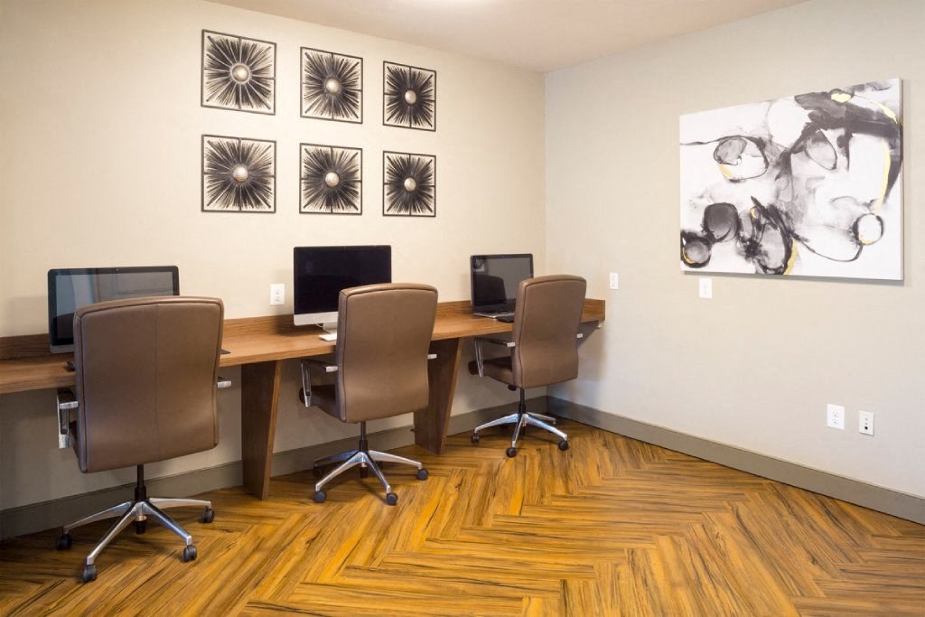 a conference room with computers and pictures on the wall