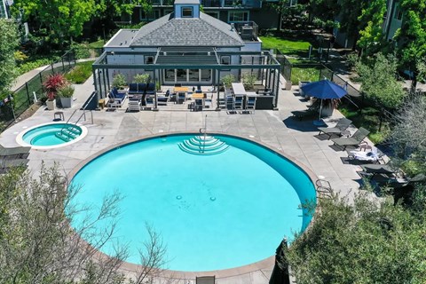 A large swimming pool with a hot tub and a gazebo.