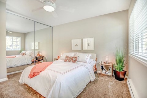 A bedroom with a large bed and a ceiling fan.