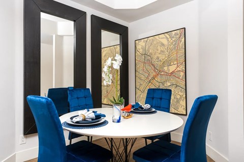 A dining room with a white table and blue chairs.