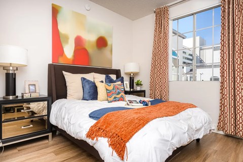 A bedroom with a large bed and a painting on the wall.