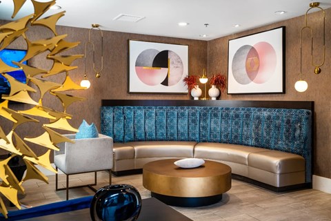 A modern living room with a blue sofa and gold decorations.