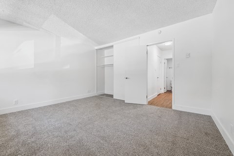 an empty living room with carpet and white walls