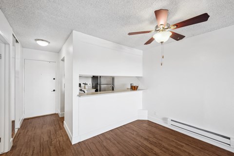 a living room with a ceiling fan and a kitchen