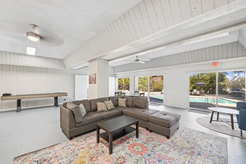 a living room with a couch and a table in front of a pool