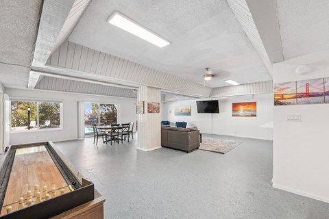 the living room and dining room of a house with white walls and a concrete floor
