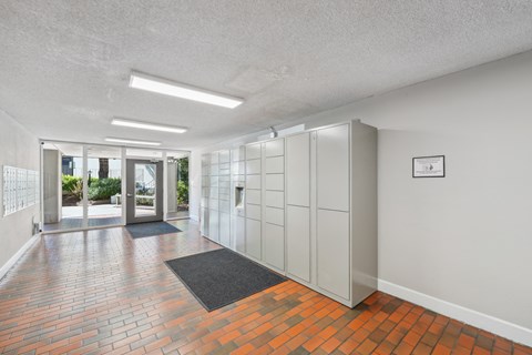 an empty room with white cabinets and a brick floor