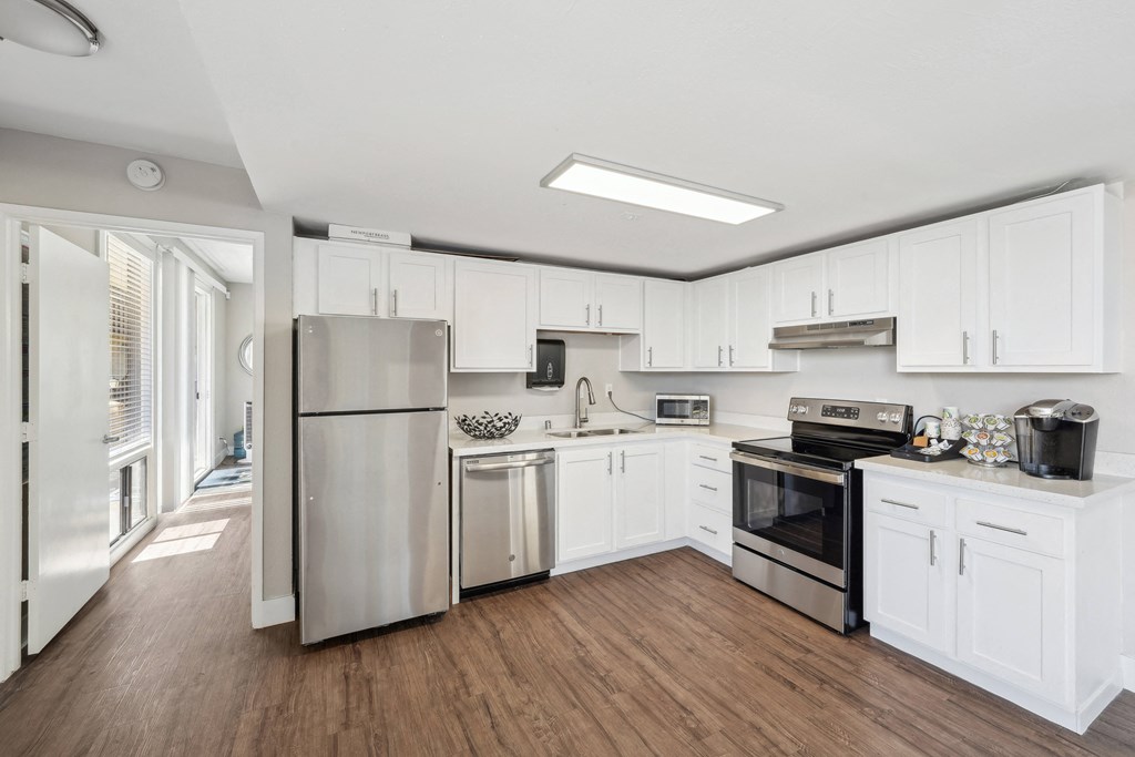 a kitchen with white cabinets and stainless steel appliances