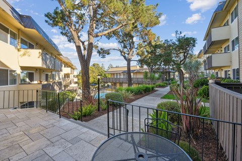 a patio with a table and chairs in front of an apartment building