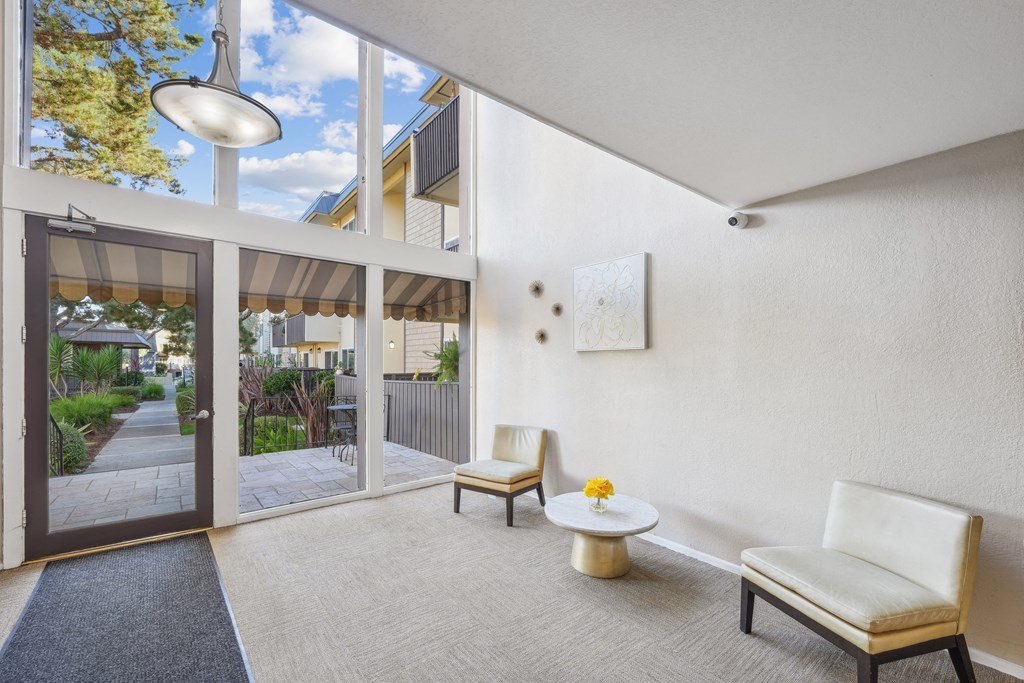 a living room with two chairs and a table and sliding glass doors