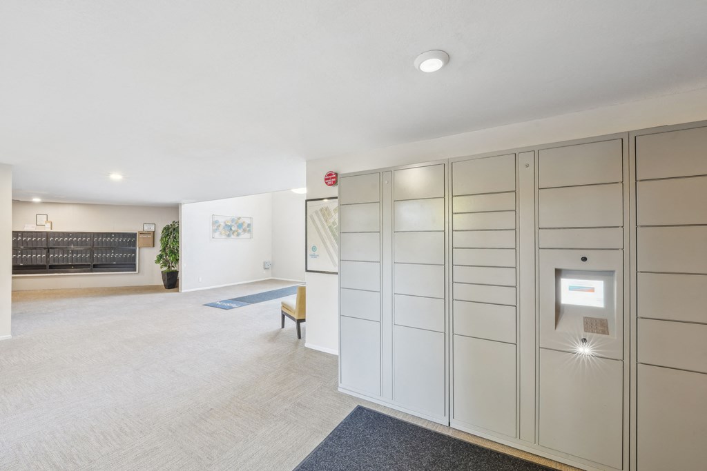 a walk in closet with white cabinets and a bench in a room with a rug