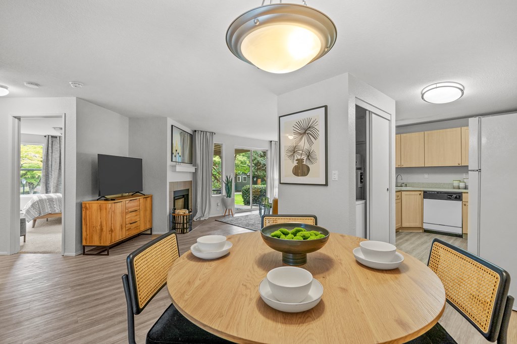 a dining area with a wooden table and chairs and a flat screen tv on the wall