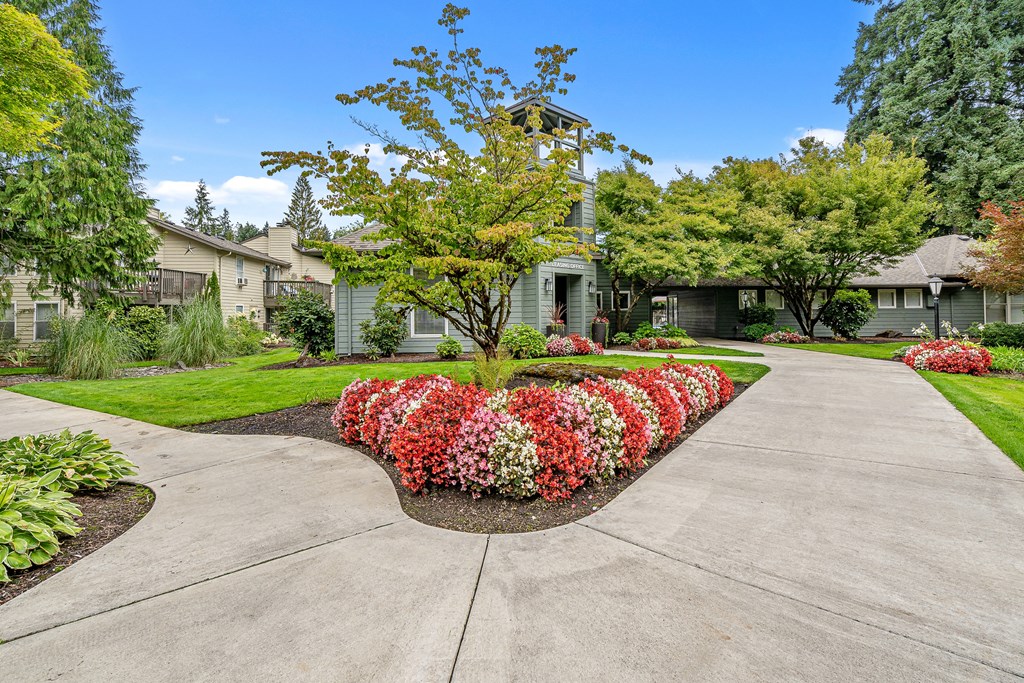 a large concrete driveway with flowers in the middle of it