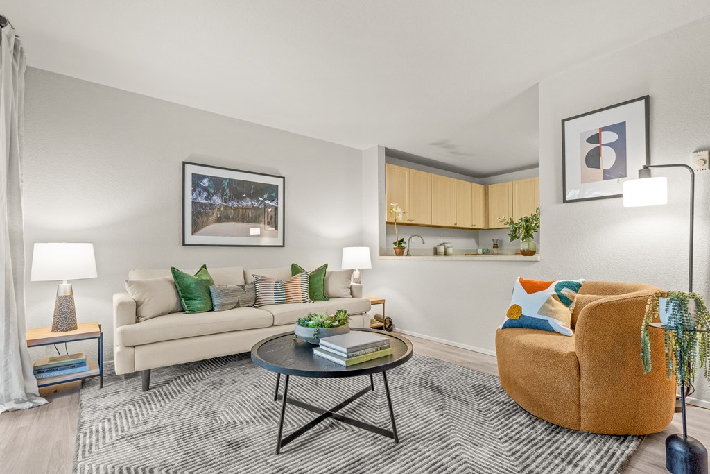 a living room with a beige couch and a brown chair with a coffee table in the