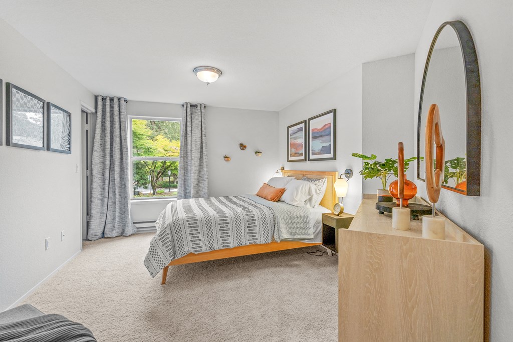 a bedroom with a bed and a dresser with a mirror