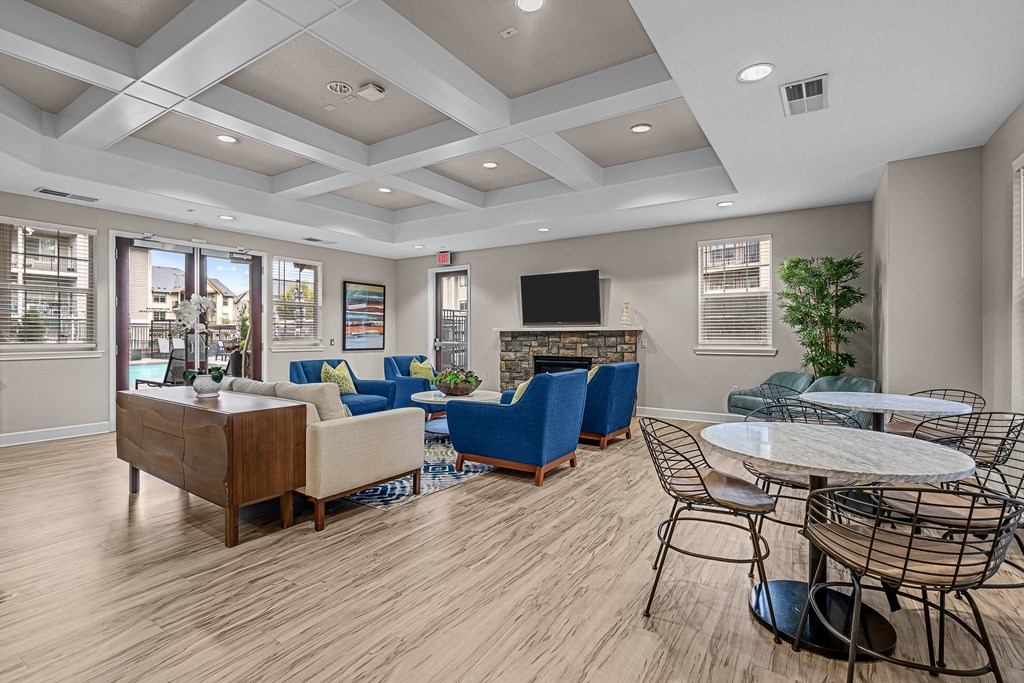 a clubhouse with couches chairs and tables and a fireplace