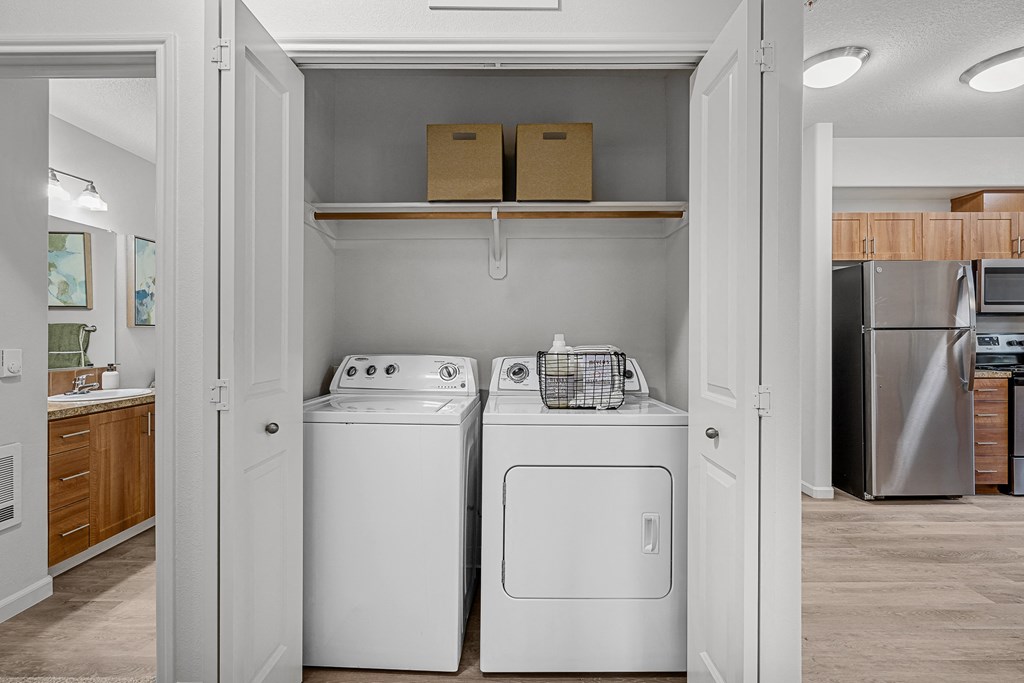 a laundry room with two washer and dryers and a stainless steel refrigerator