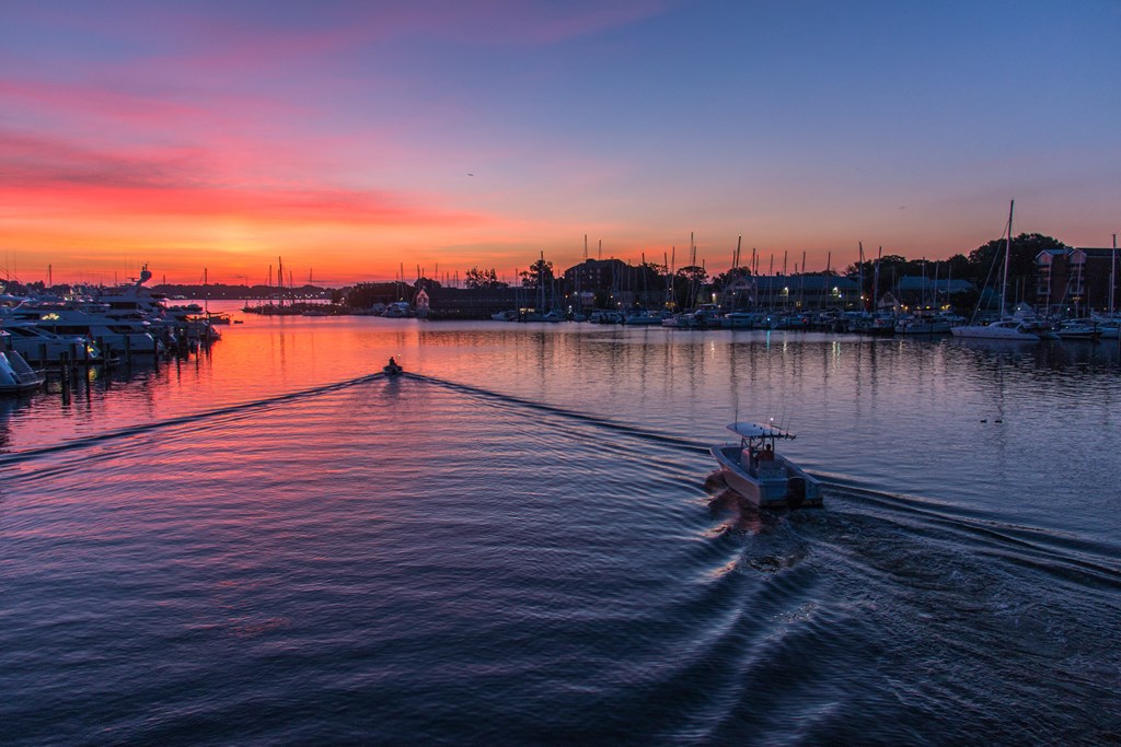 a boat on the water at sunset in a marina