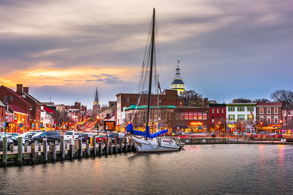 a sailboat docked at a dock in a harbor at dusk
