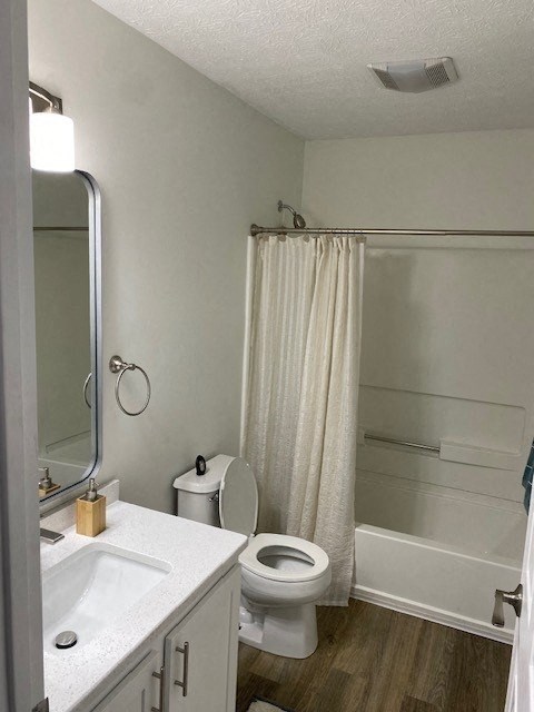A white bathroom with a toilet, sink, and shower.