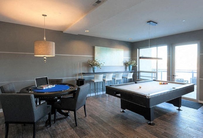 a living room with a pool table and a bar