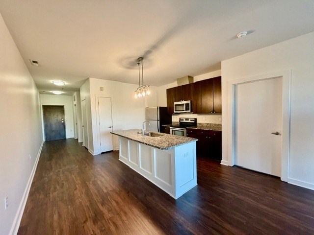 A kitchen with dark wood floors and white cabinetry.