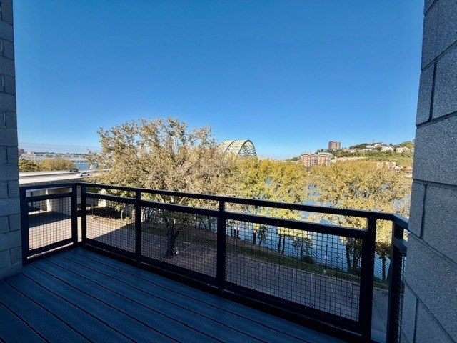 A balcony with a black railing overlooking a body of water.
