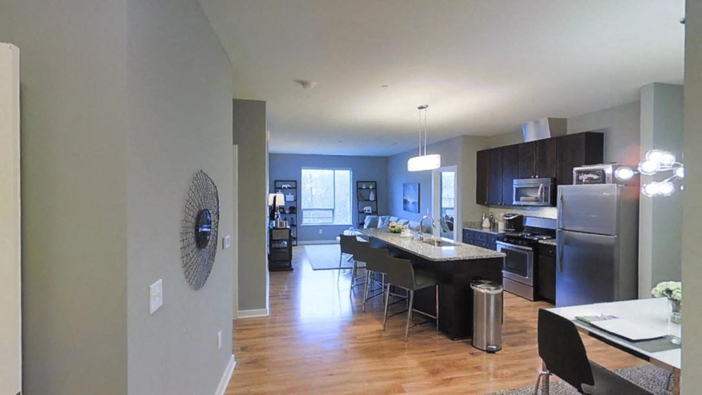 a kitchen and dining room with stainless steel appliances and wood flooring