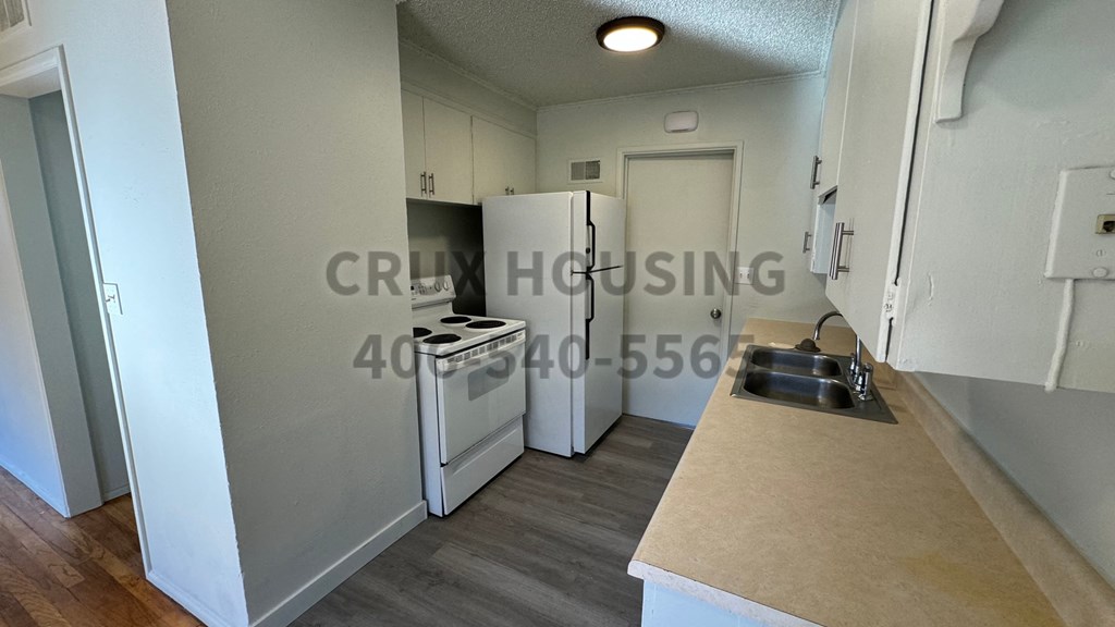 A kitchen with a white fridge, a white oven, and a wooden counter.