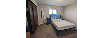 A bedroom with a bed, dresser, and mirror.