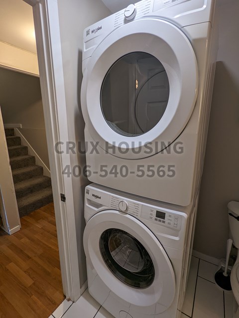 A white front loading washing machine in a laundry room.