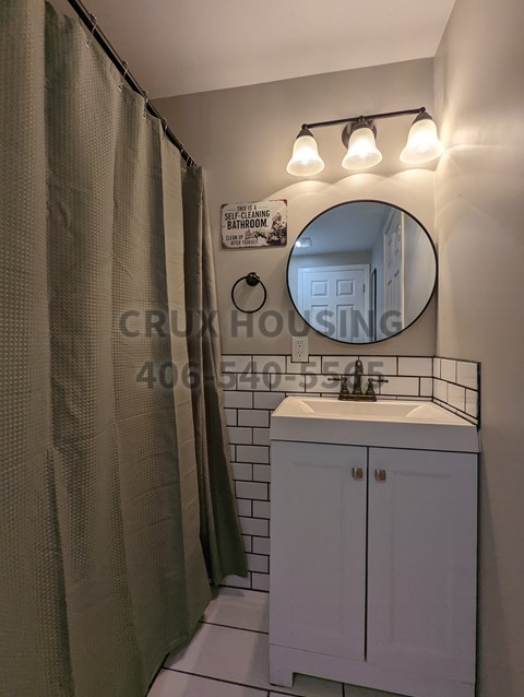 A bathroom with a white sink and a mirror.