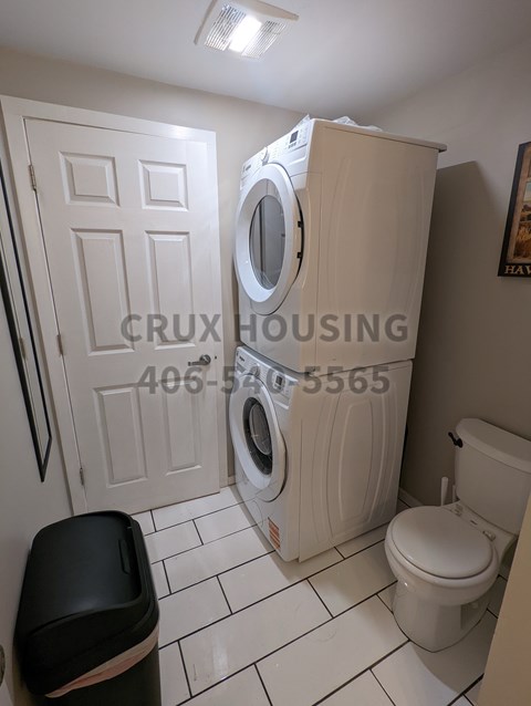 A small bathroom with a washer and dryer built into the cabinet.