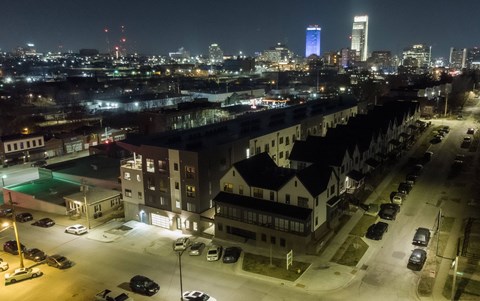 A cityscape at night with a brightly lit building in the distance.