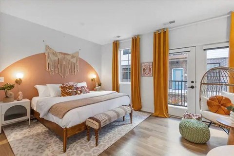 A bedroom with a large bed and a round rug.