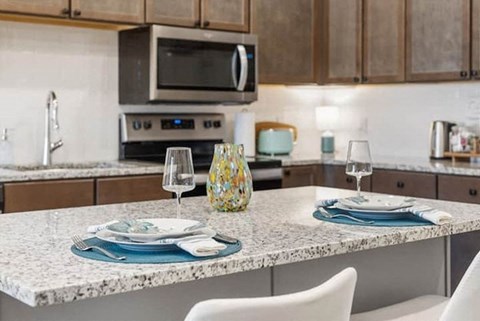 A kitchen with a table set for two.