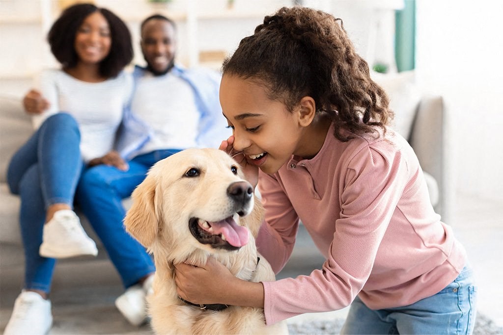 a girl playing with a dog with her family in the background at Morea Apartments, Florida, 33062