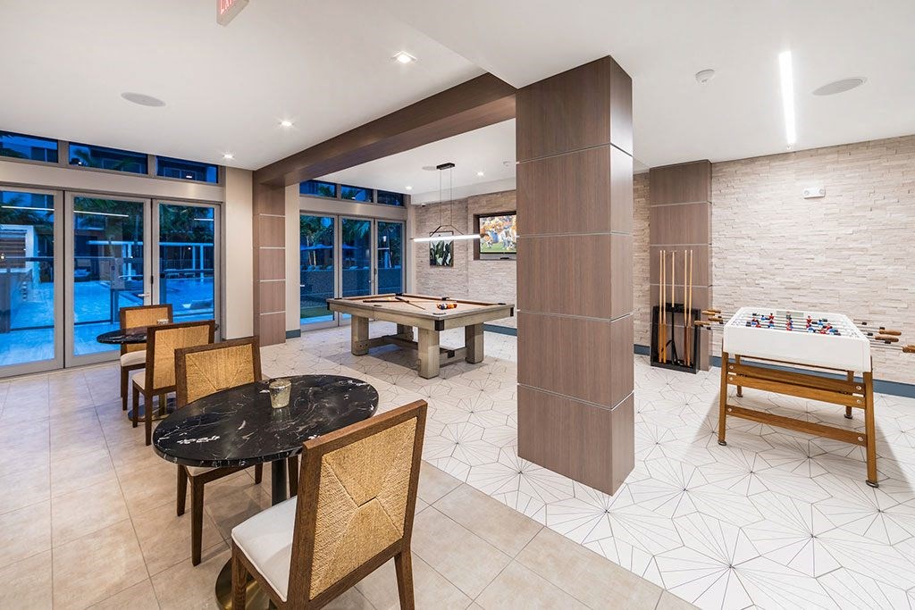 a game room with a pool table and tables