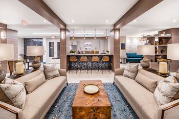 Clubhouse with a large sectional sofa, a coffee table, and a dining area in the background. at Morea Apartments, Pompano Beach, 33062