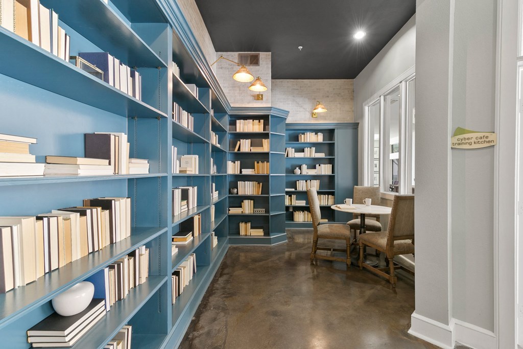 a library with blue bookshelves and a table with chairs