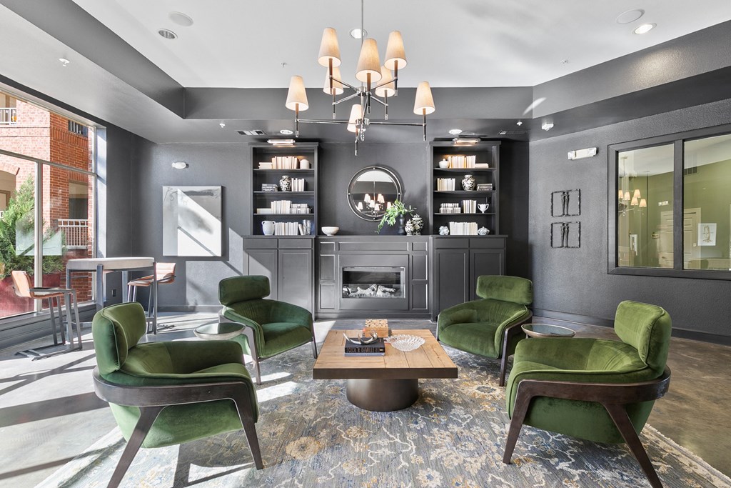 a living room with green chairs and a fireplace