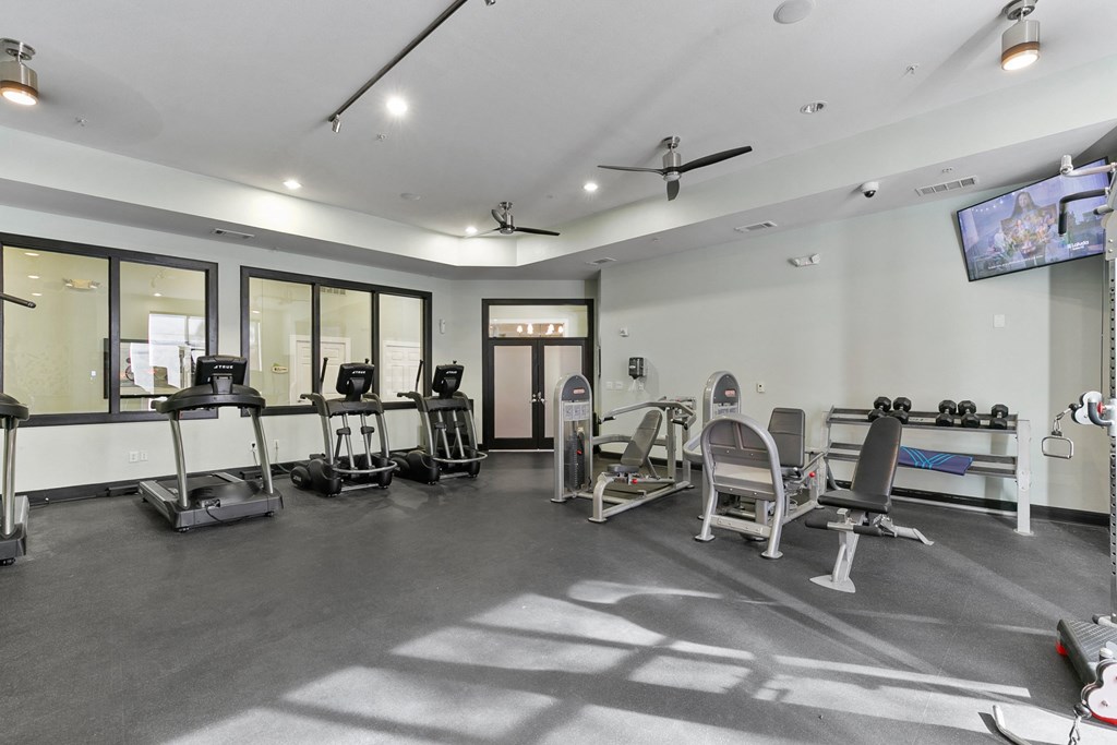 a fitness room with treadmills and other exercise equipment