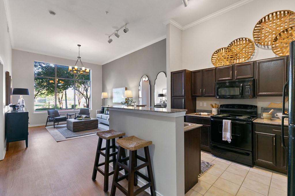a kitchen and living room with a bar and stools