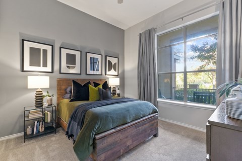 a bedroom with a bed and a large window