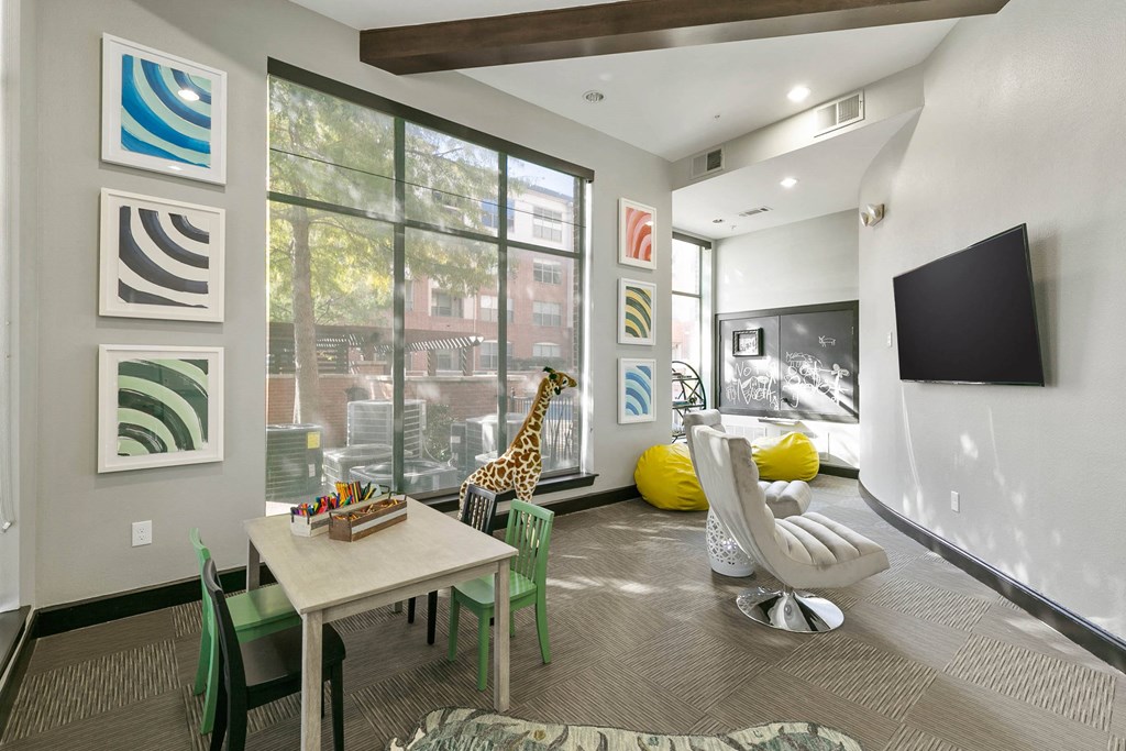 a living room with a table and a giraffe in front of a window