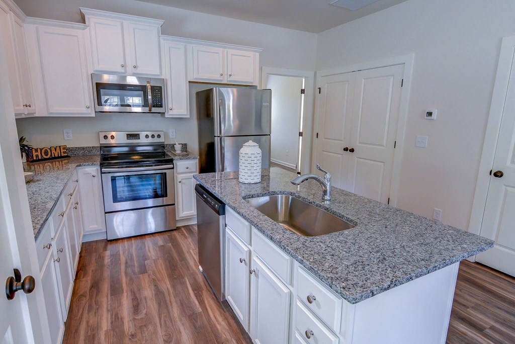 a kitchen with white cabinets and a granite counter top