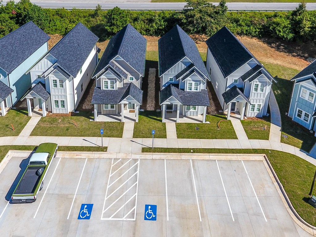 an aerial view of a row of houses with cars parked in front of them