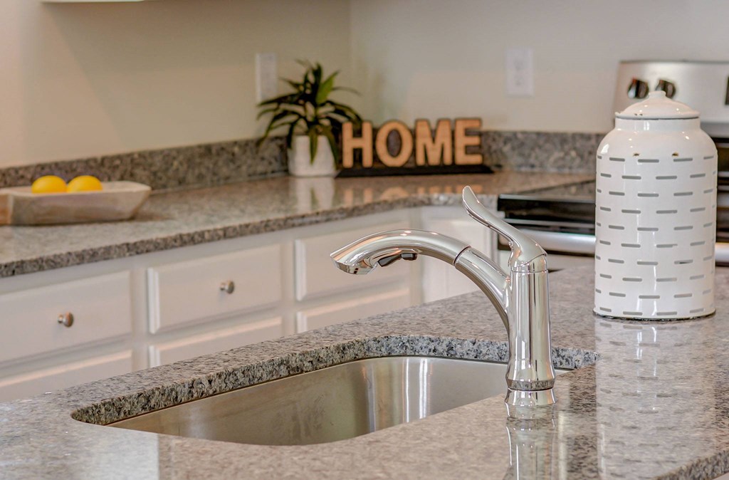 a kitchen with granite countertops and a stainless steel sink